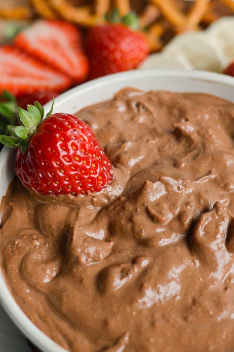 Close up of chocolate vegan fruit dip with a strawberry.