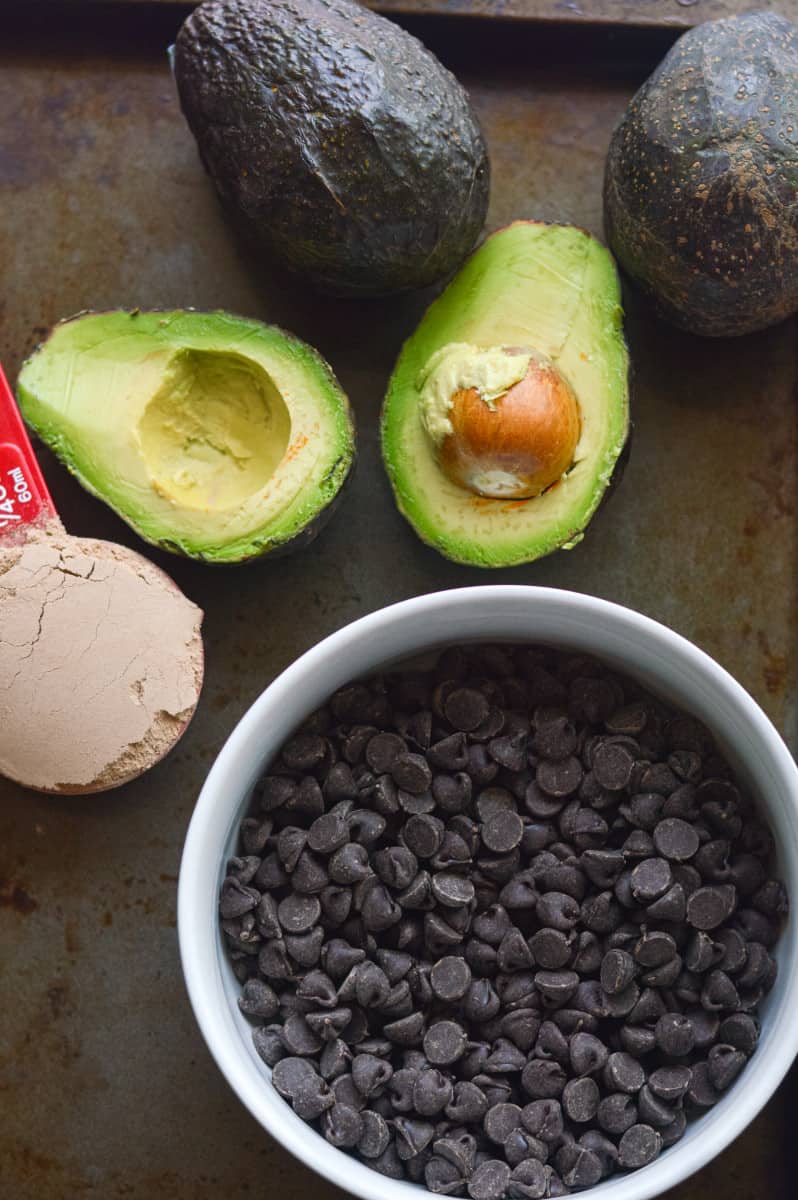 Ingredients for fudge including avocados, chocolate and protein powder.