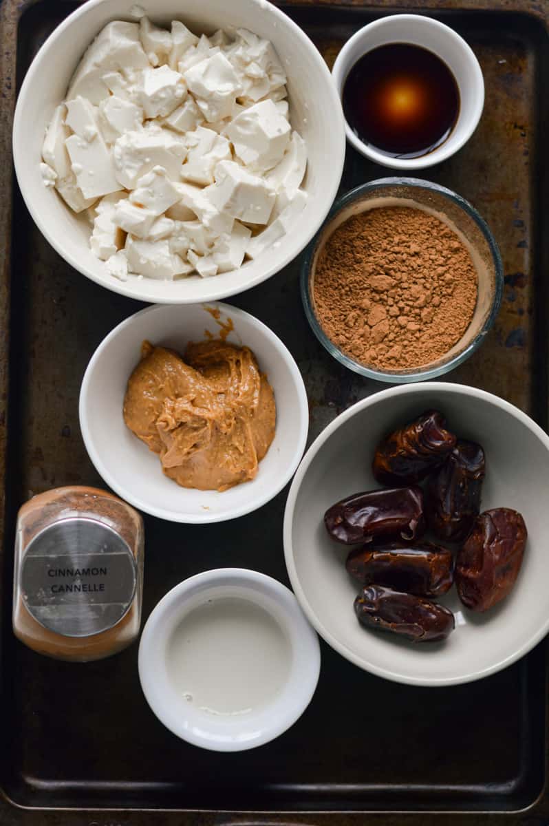 Ingredients for vegan fruit dip including tofu, dates and cocoa powder.
