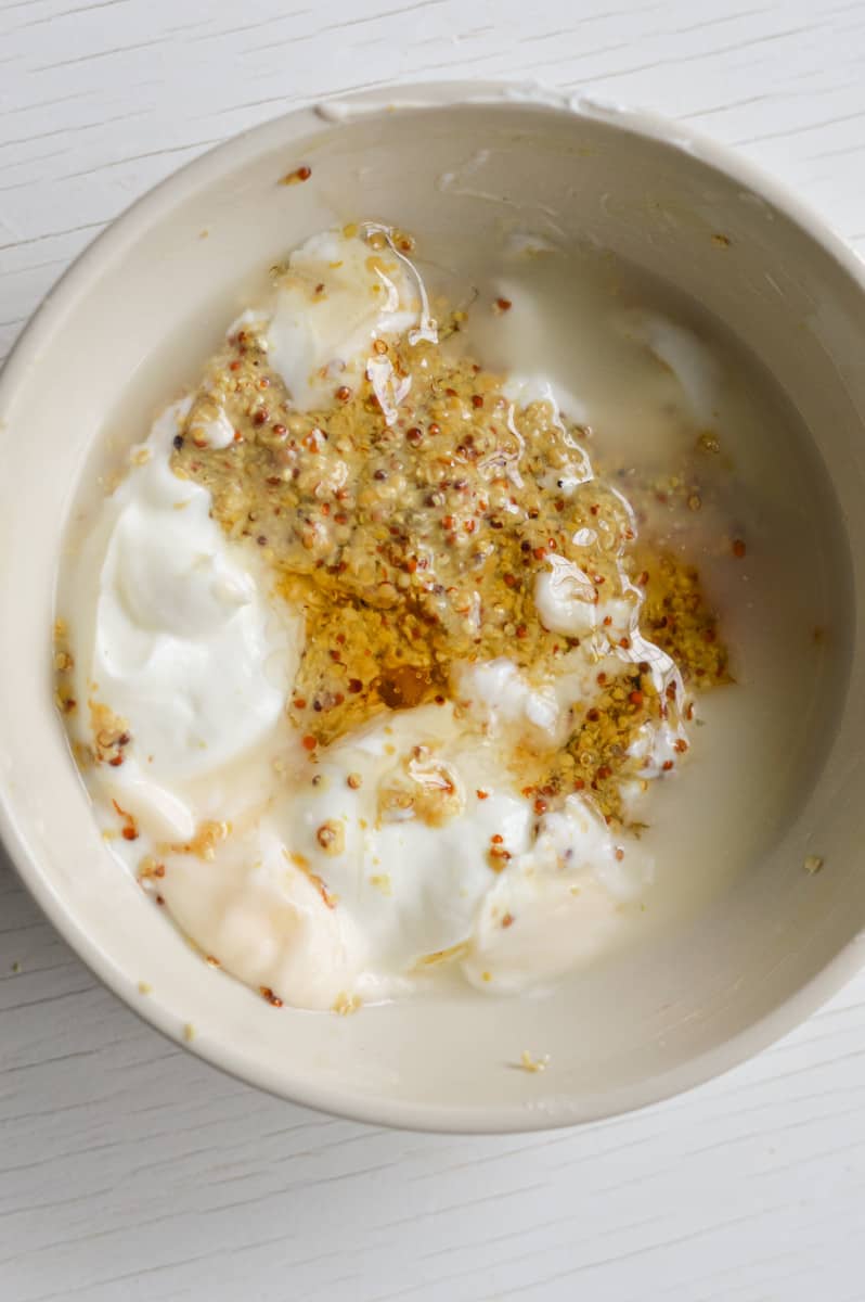 Mixing together honey mustard sauce in a bowl.