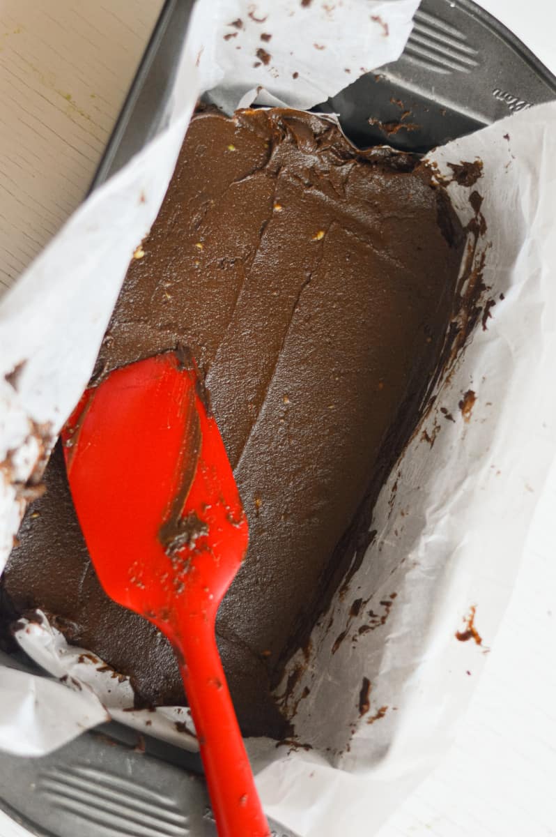 Spreading avocado fudge in a pan.