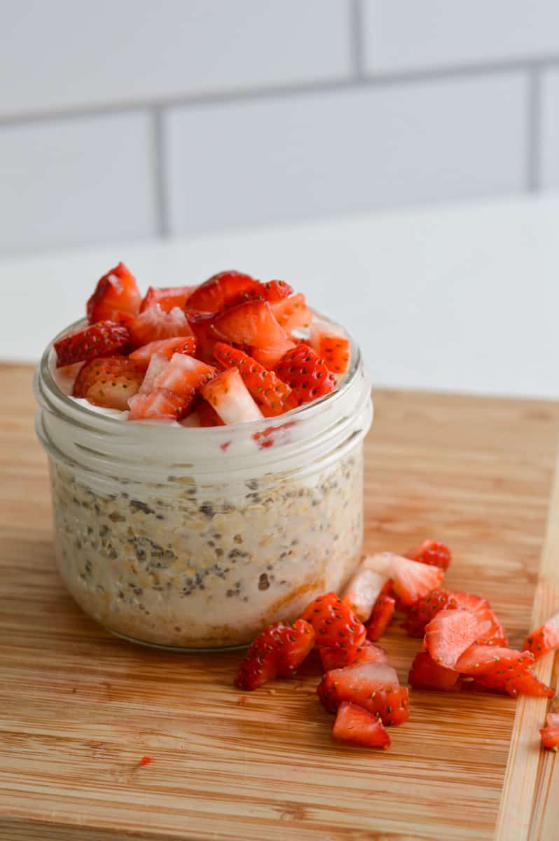 Jar of cheesecake overnight oats with strawberries.