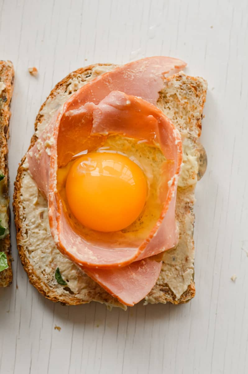 Making a well with turkey bacon and cracking in an egg.
