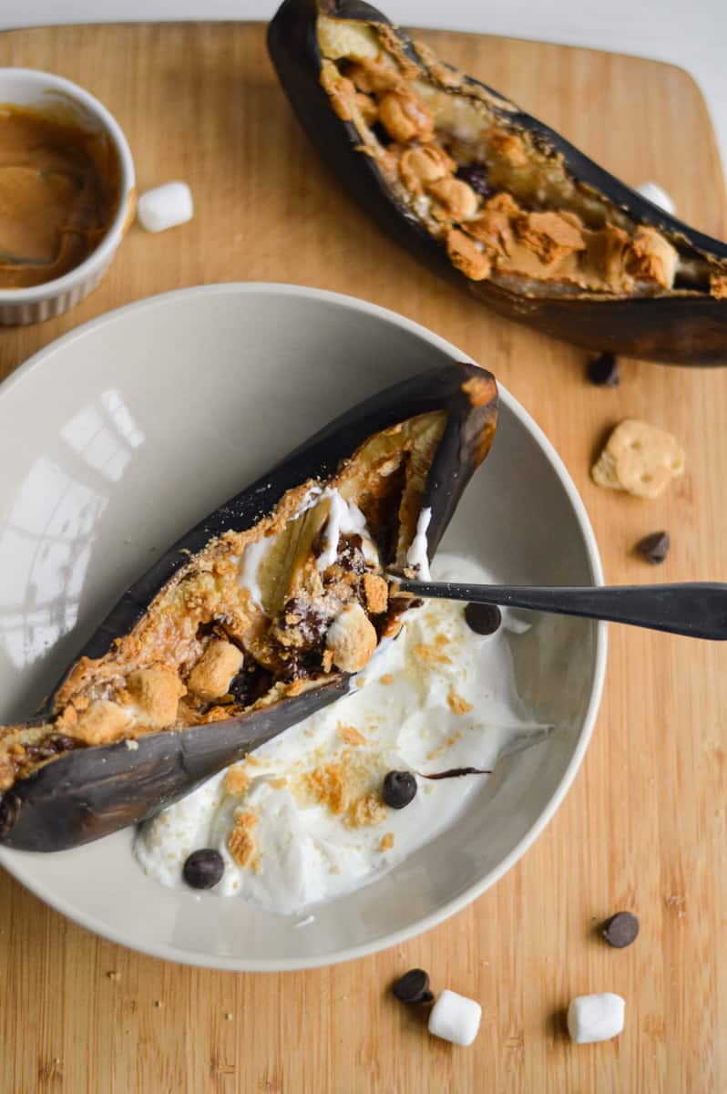 Air fried banana split served with yogurt in a bowl.