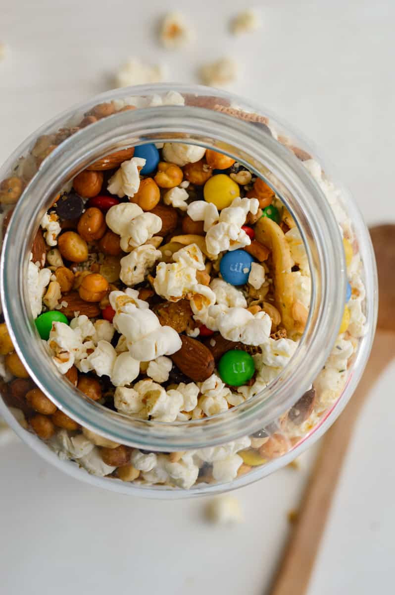 Birds eye of popcorn trail mix in a glass jar.