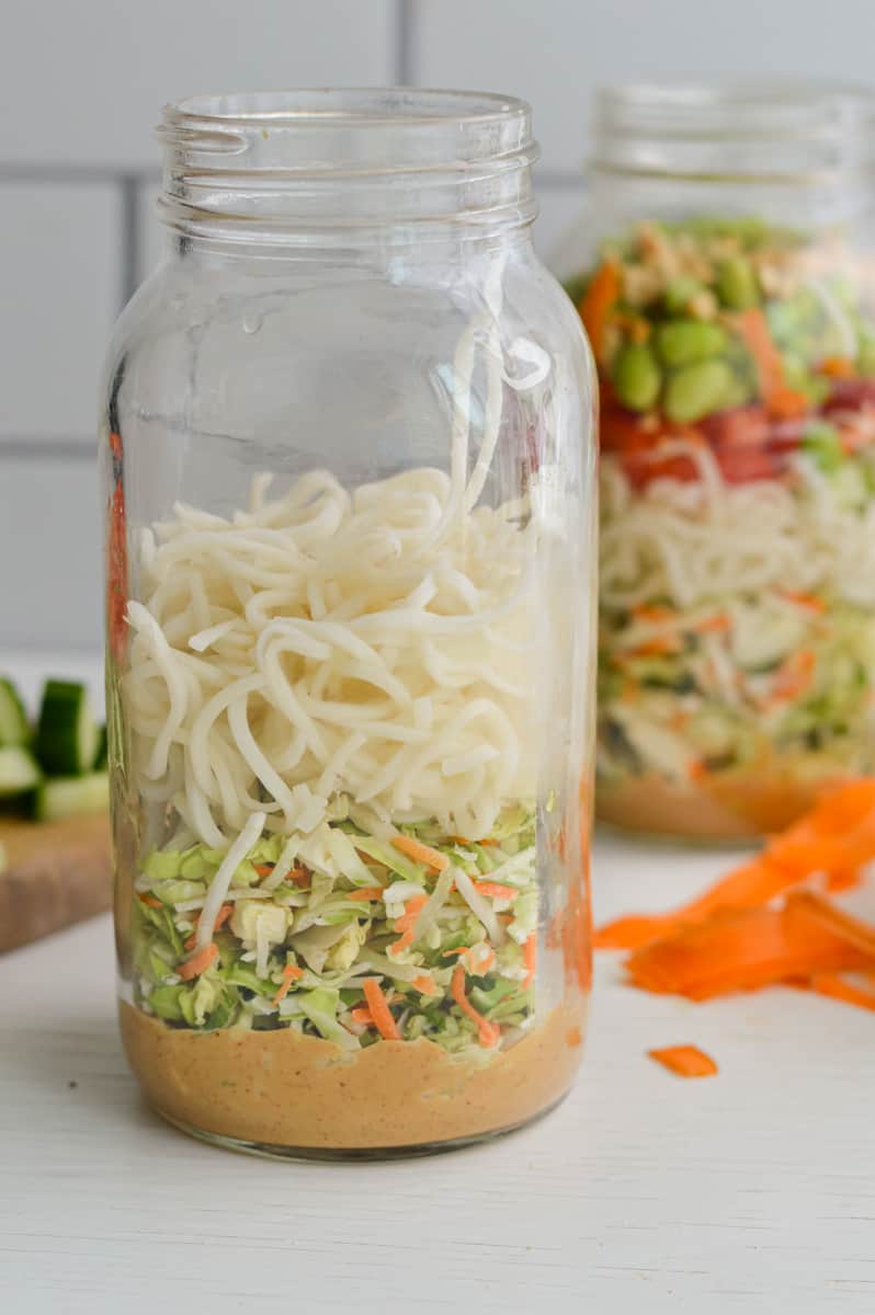Layering noodles in a mason jar.