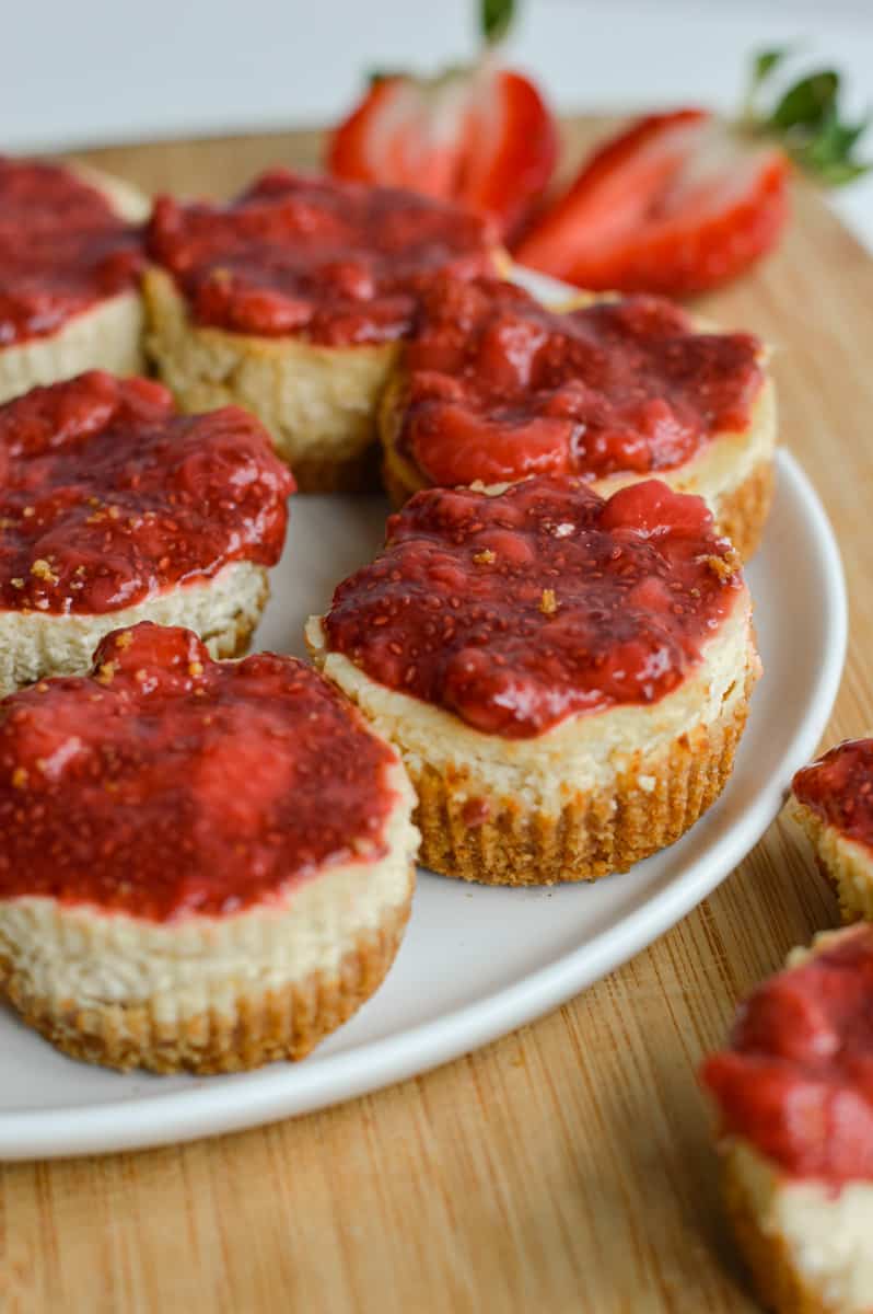 Mini protein cheesecakes topped with chia jam on a plate.