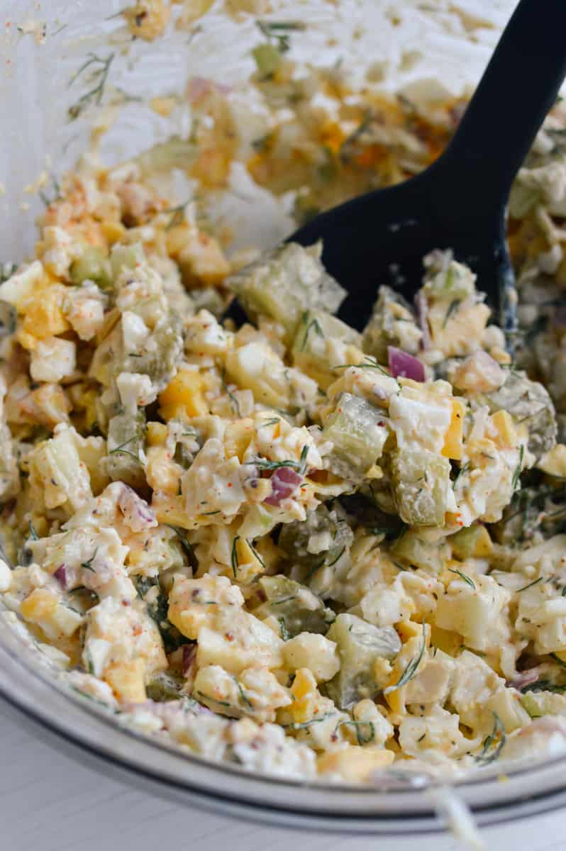Mixing egg salad ingredients.