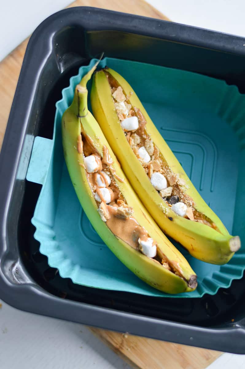 Placing stuffed bananas in air fryer.