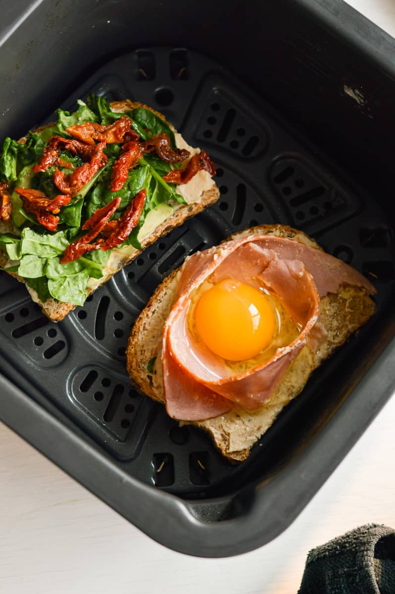 Placing halves of sandwich in air fryer.