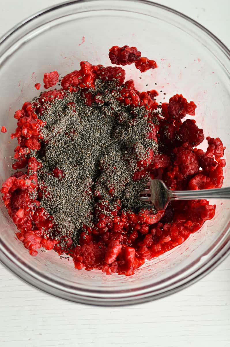 Mixing raspberries and chia seeds.