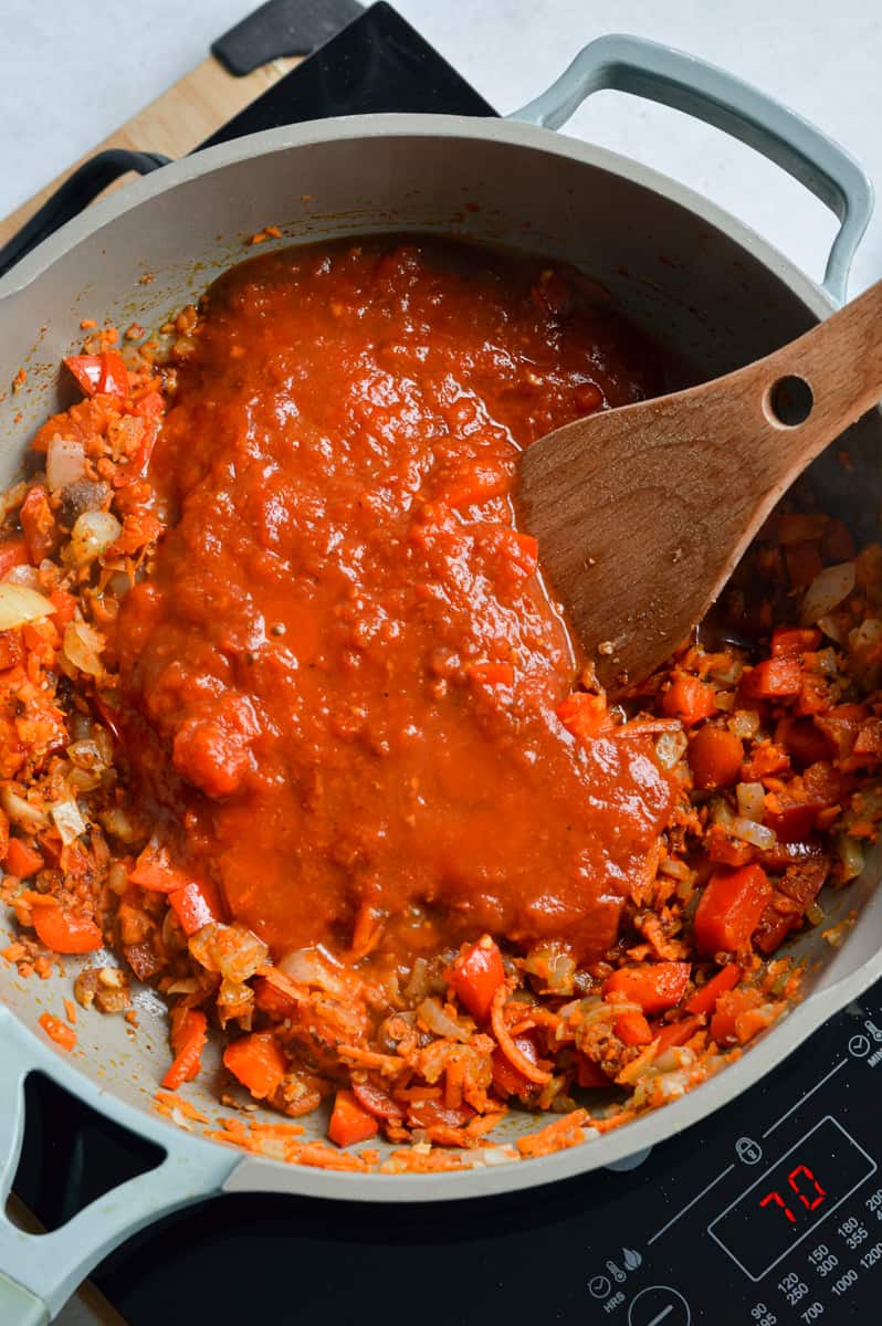 Adding barbecue sauce and seasoning into veggie mixture.