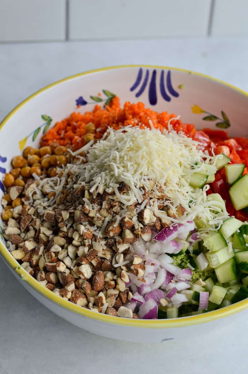 Adding broccoli salad ingredients to a bowl.