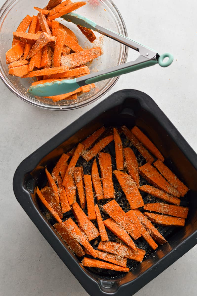 Adding sweet potatoes into the air fryer.