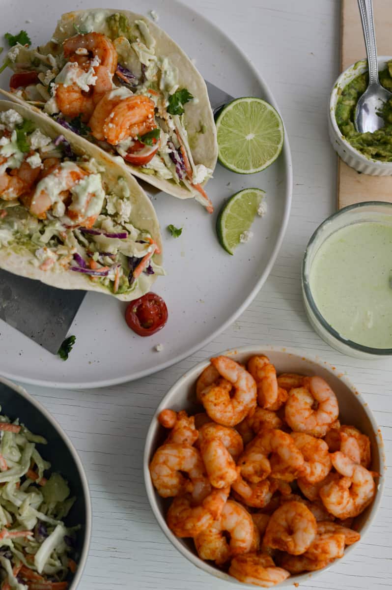 Plate of shrimp tacos with a bowl of air fryer shrimp.