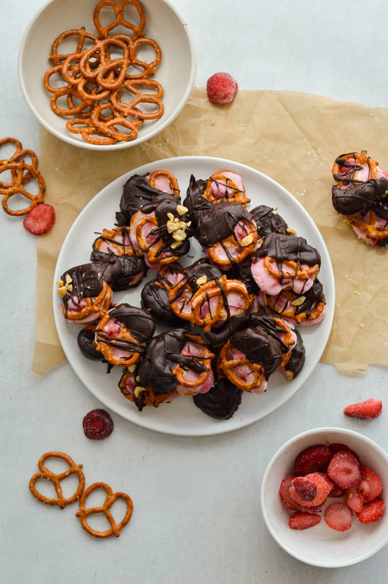 Bowl of pretzels and plate of strawberry yogurt pretzels.