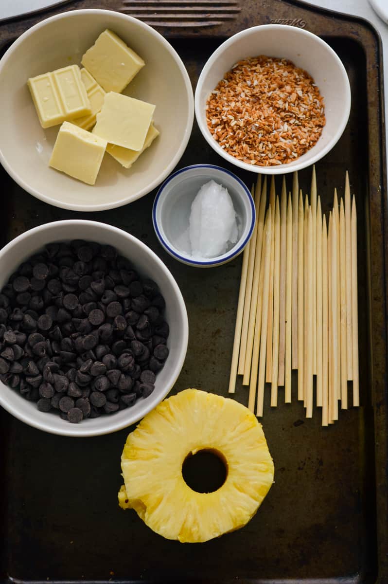 Ingredients including pineapple, coconut, coconut oil, chocolate and skewers.