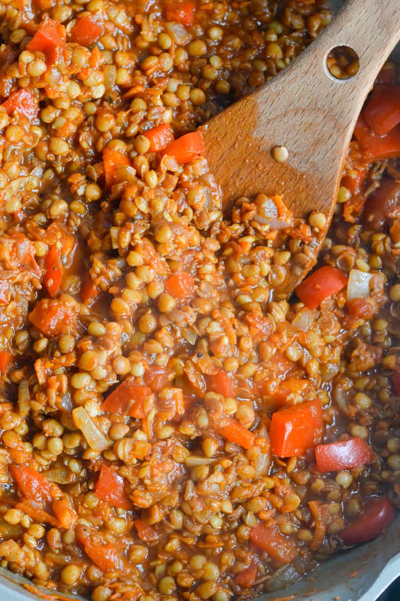 Mixing lentils into cooked veggies.