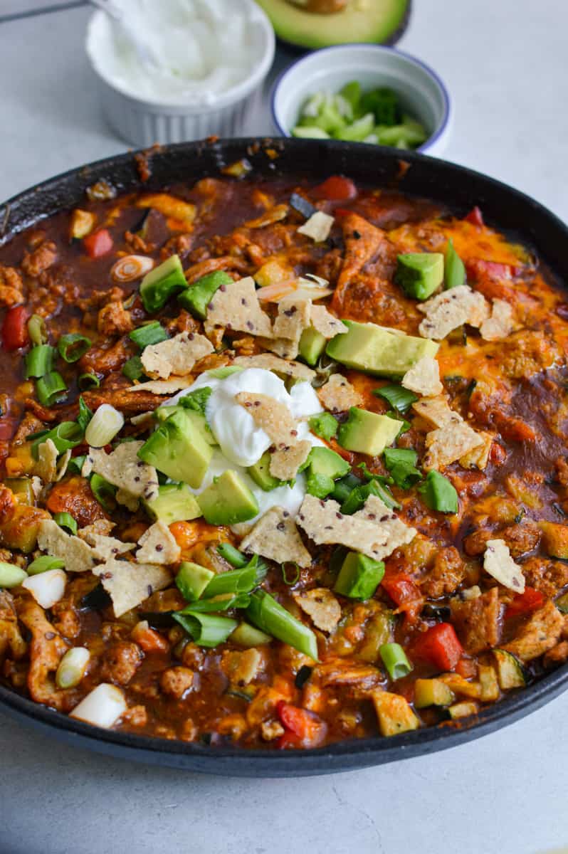 Lazy enchilada skillet topped with green onions, avocado and Greek yogurt.