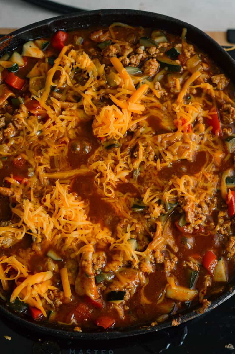 Topping lazy enchilada with cheese.