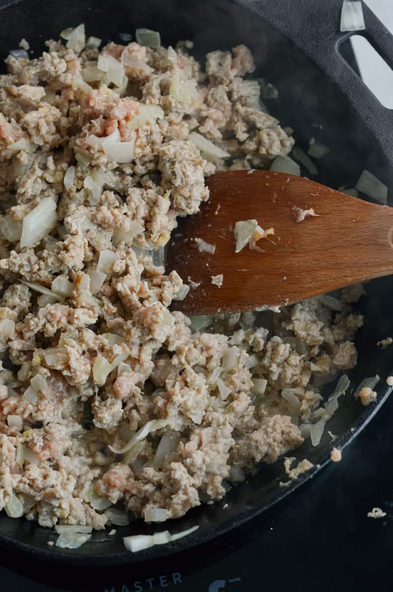 Sauteeing ground chicken in a skillet.