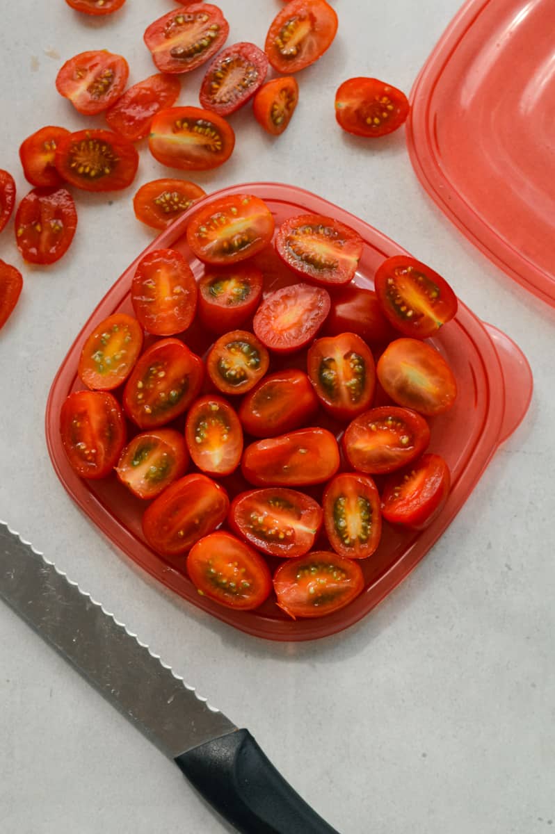 Slicing cherry tomatoes in half.
