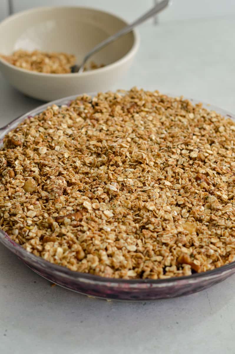 Adding gluten free crisp topping to berries.