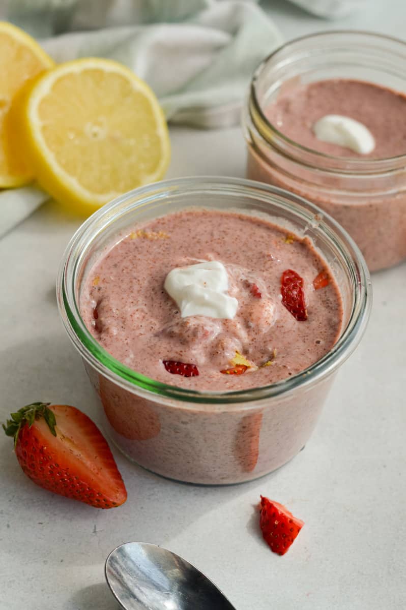 Adding Greek yogurt and strawberries to blended chia pudding jars.