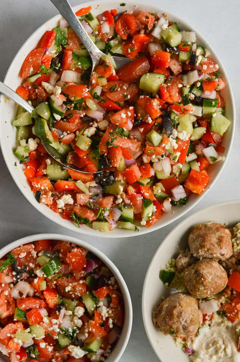 Serving cucumber salad with mediterranean bowls.
