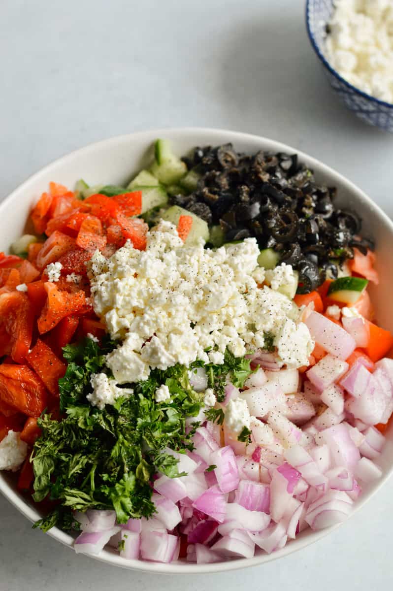Adding ingredients for cucumber salad to mix.