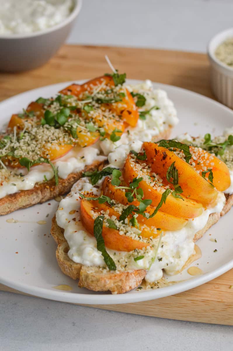 Two slices of peach toast with cottage cheese.