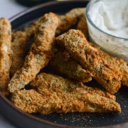 Plate of air fryer vegan zucchini fries served with garlic yogurt dip.