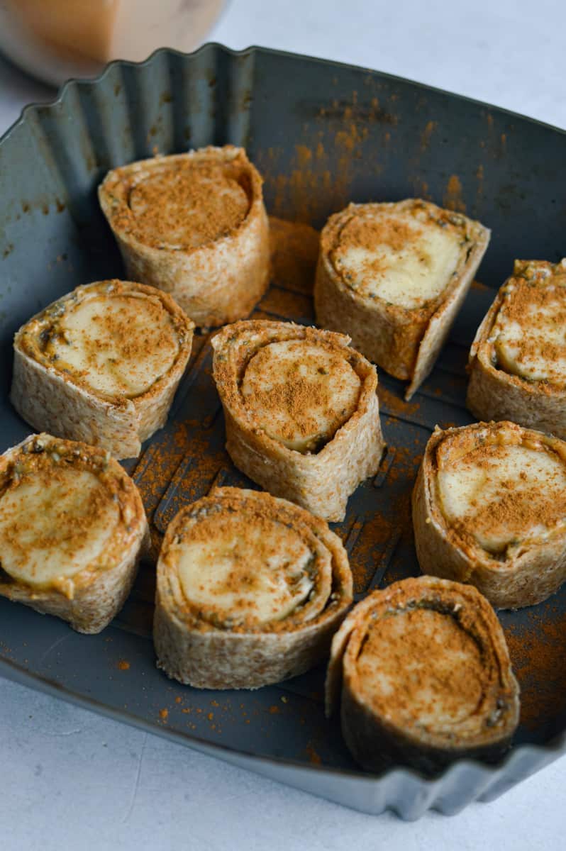 Arranging banana bites in air fryer basket.