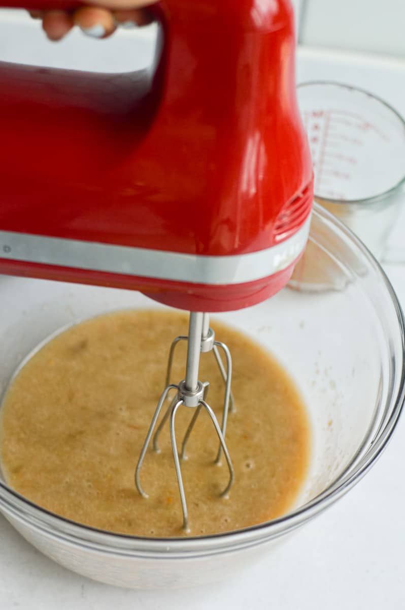 Beating flax egg, maple syrup, olive oil, vanilla extract and mashed bananas with a mixer.

