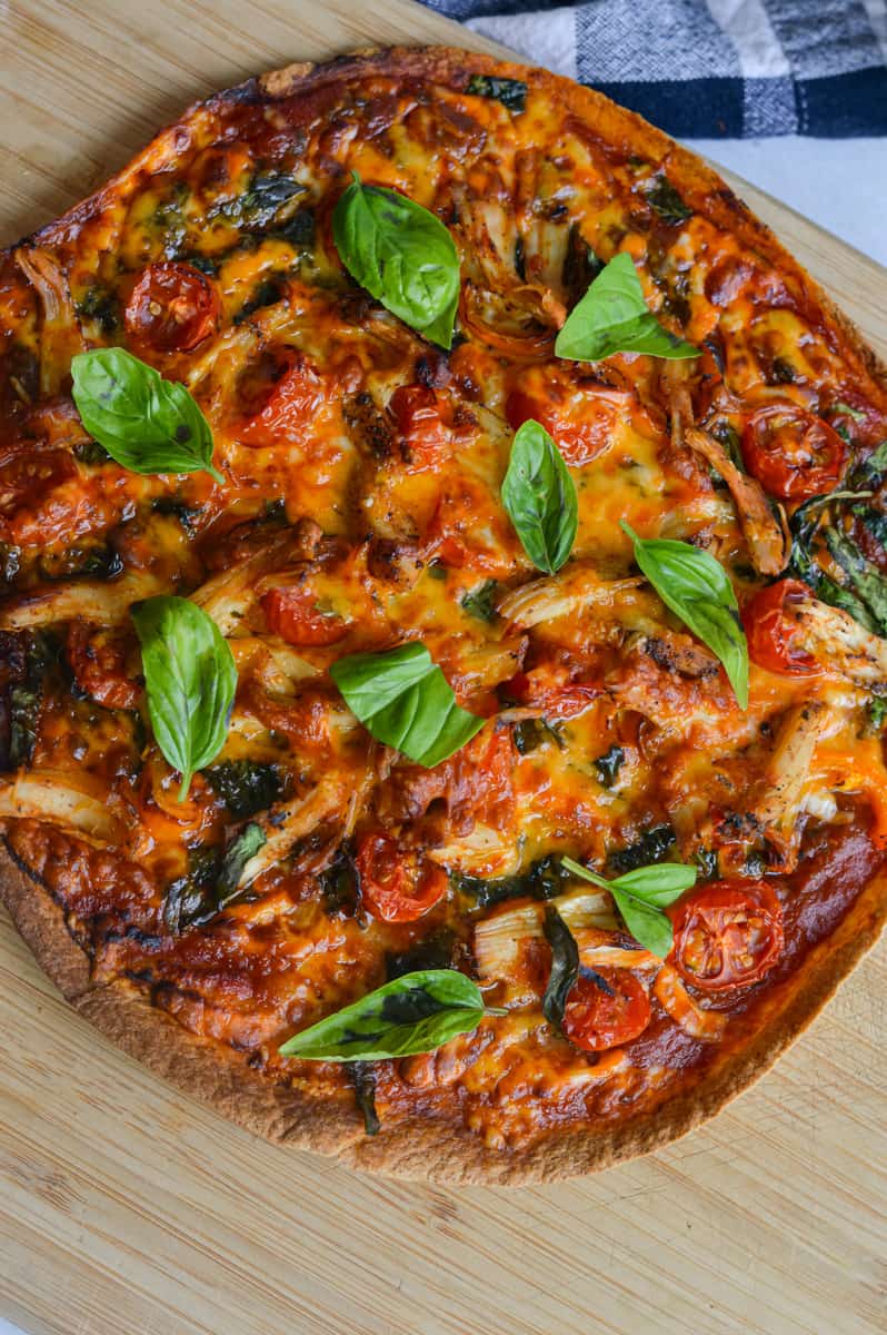 Birds eye of air fryer tortilla pizza topped with fresh basil.