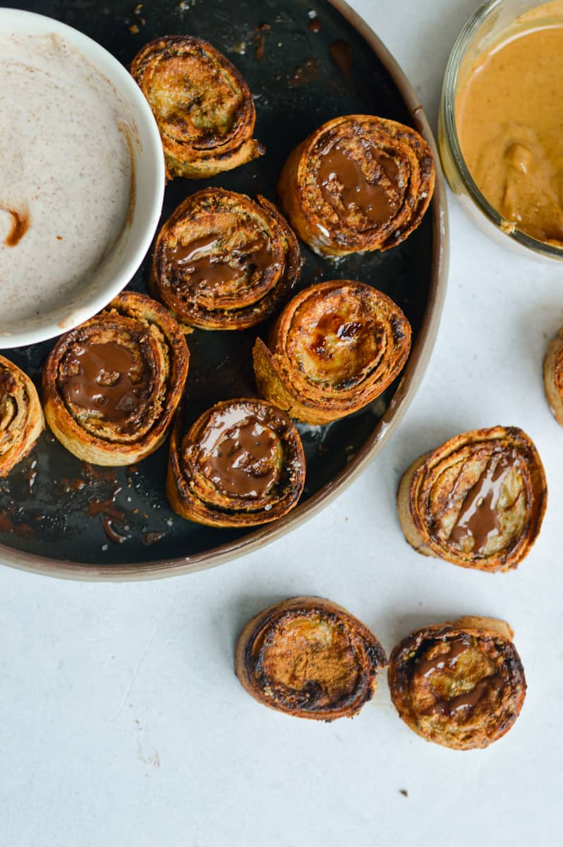 Birds eye of peanut butter banana roll ups on a plate, served with yogurt dip.