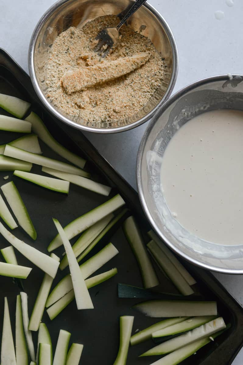 Preparing a bowl of batter and a bowl of breadcrumbs.