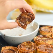 Dipping a peanut butter banana bite in yogurt dip.