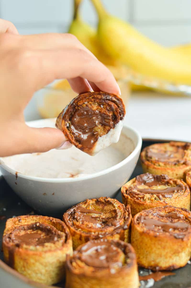 Dipping a peanut butter banana bite in yogurt dip.