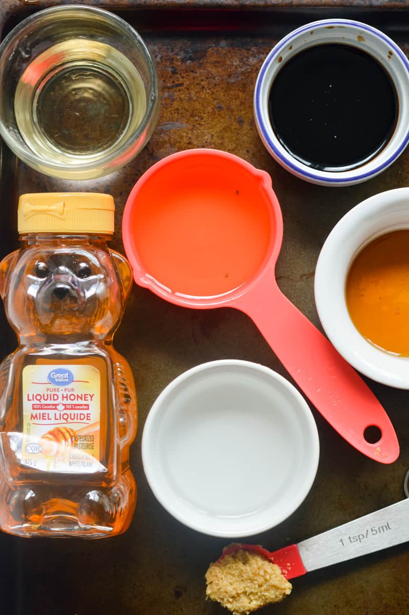 Sesame ginger salad dressing ingredients including honey, rice vinegar, soy sauce, olive oil, sesame oil and ginger.