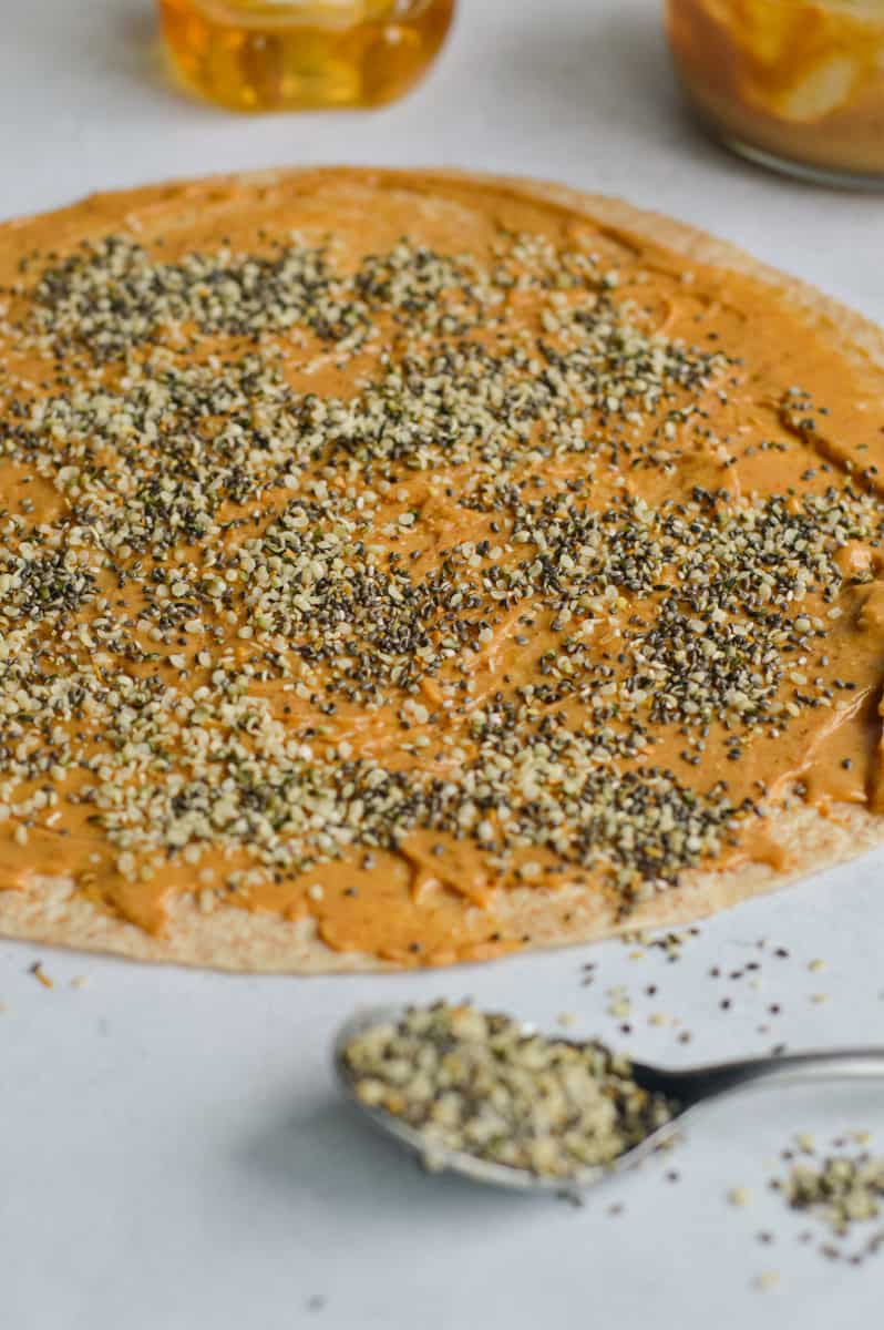 Sprinkling hemp seeds on tortilla.