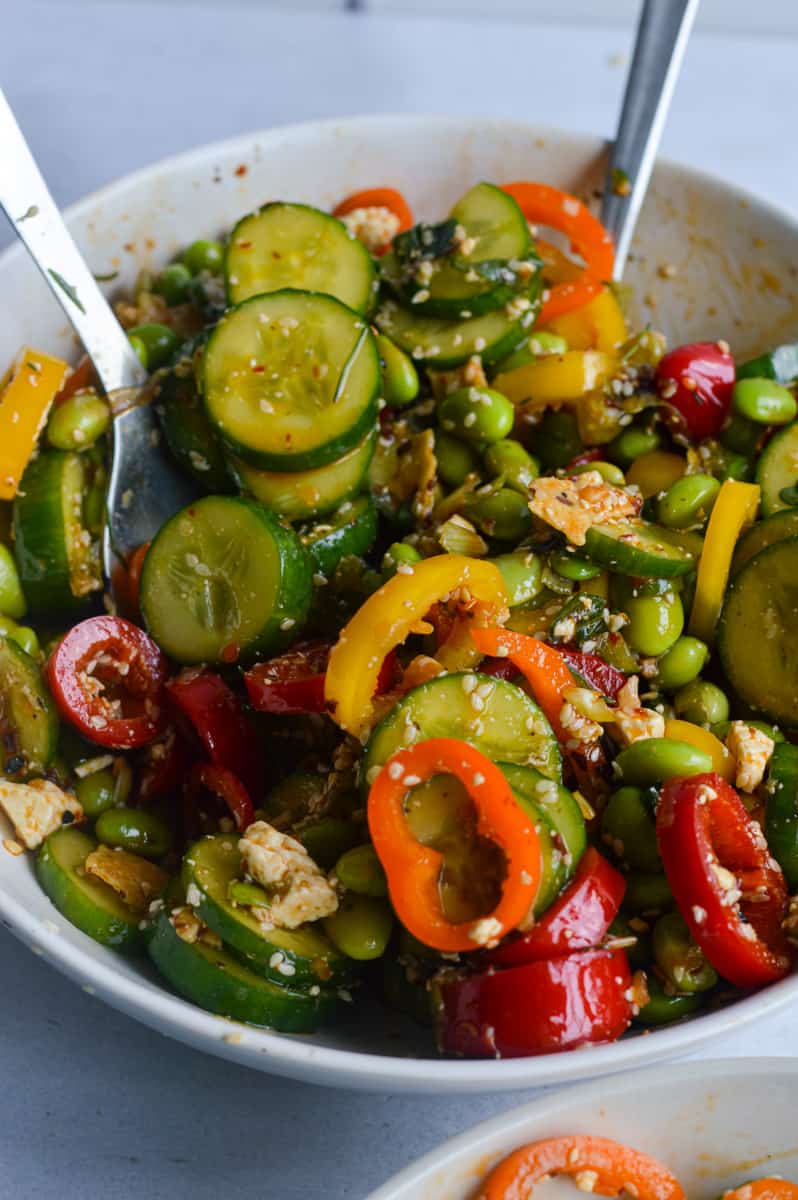 Tossing cucumber pepper salad.