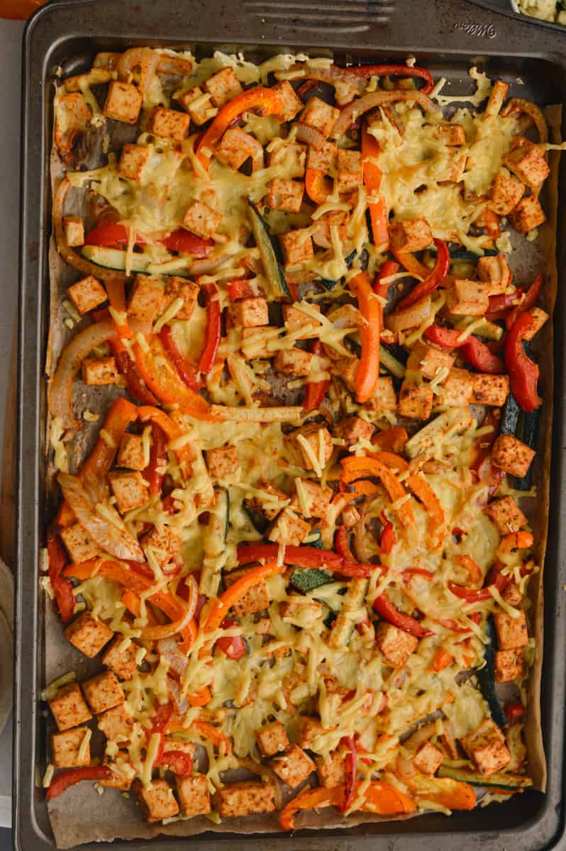 Adding vegan cheese to fajita filling.