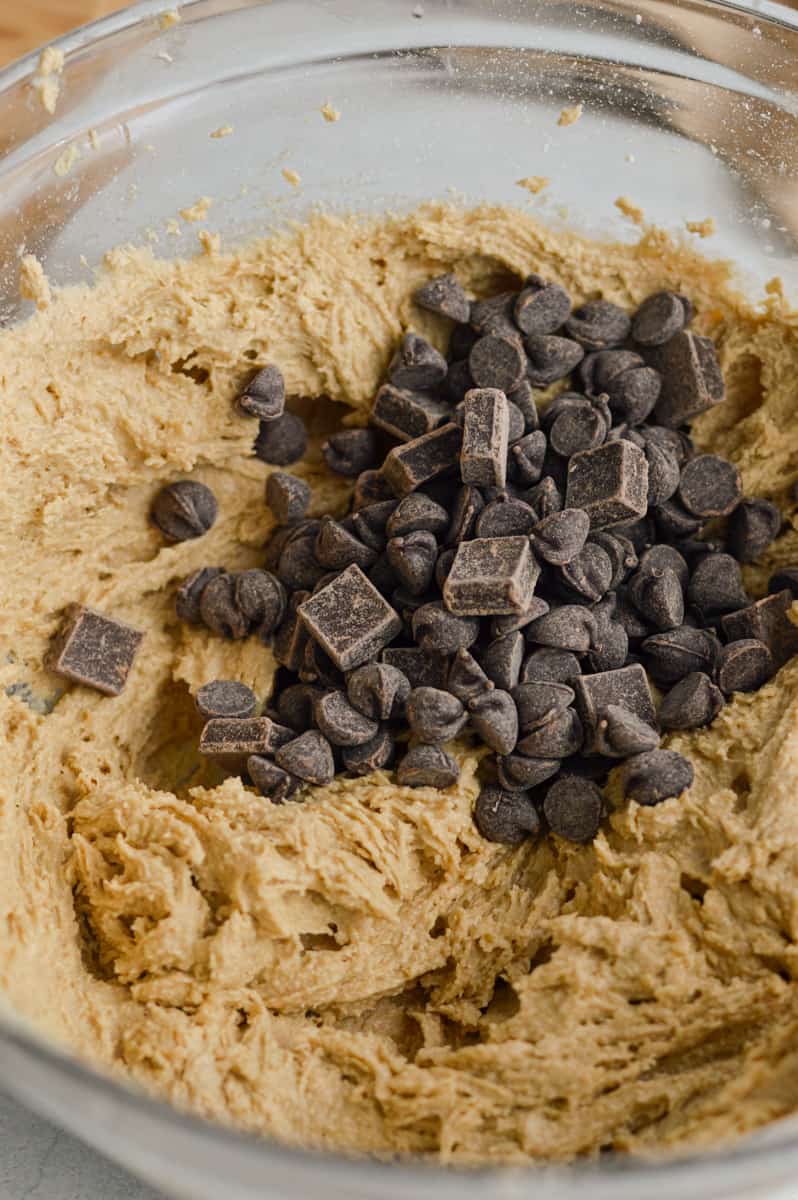 Adding oat flour and folding chocolate chips into cookie dough.