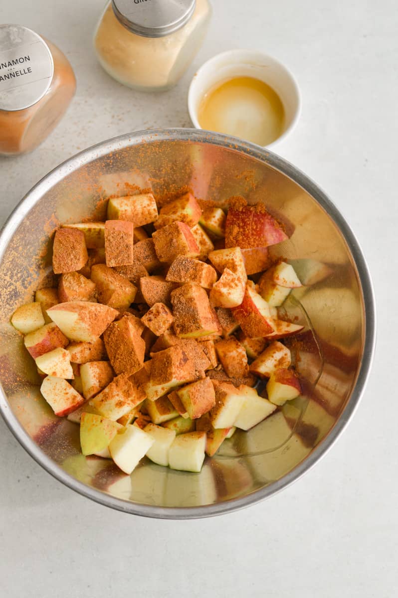 Coating apples in spices, coconut oil and syrup.