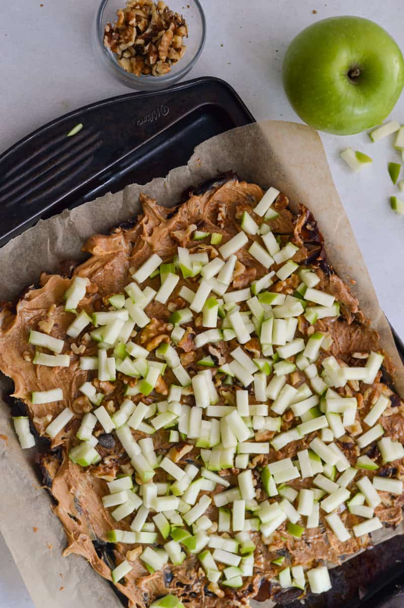 Sprinkling chopped apples and walnuts on dates.