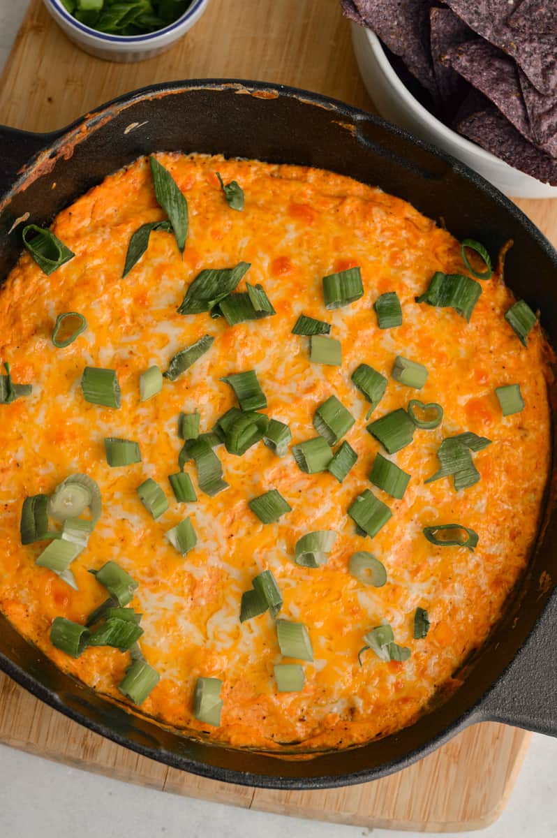 Sprinkling green onions on greek yogurt buffalo chicken dip.