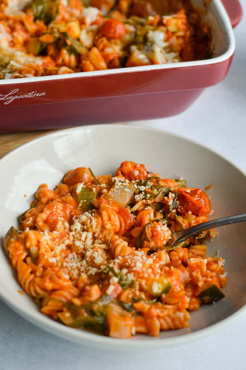 Bowl of vegan pasta bake with zucchini and vegan cheese.