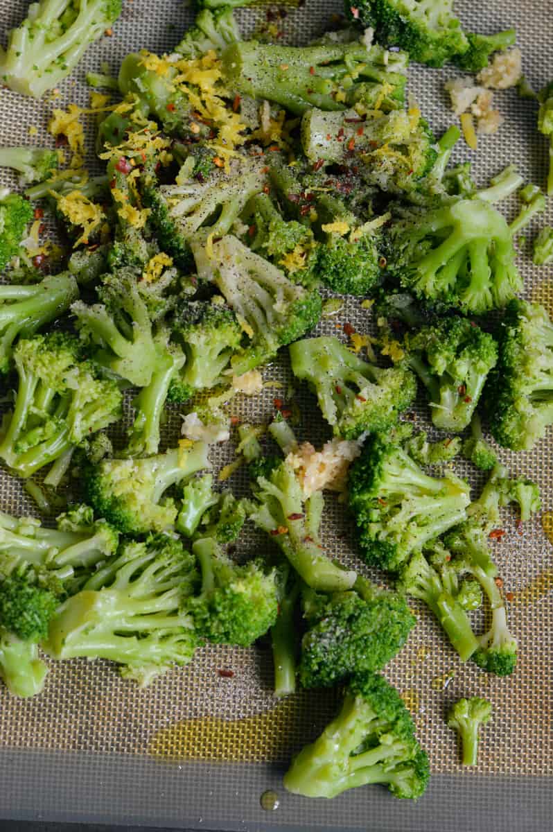 Tossing broccoli with olive oil and spices.