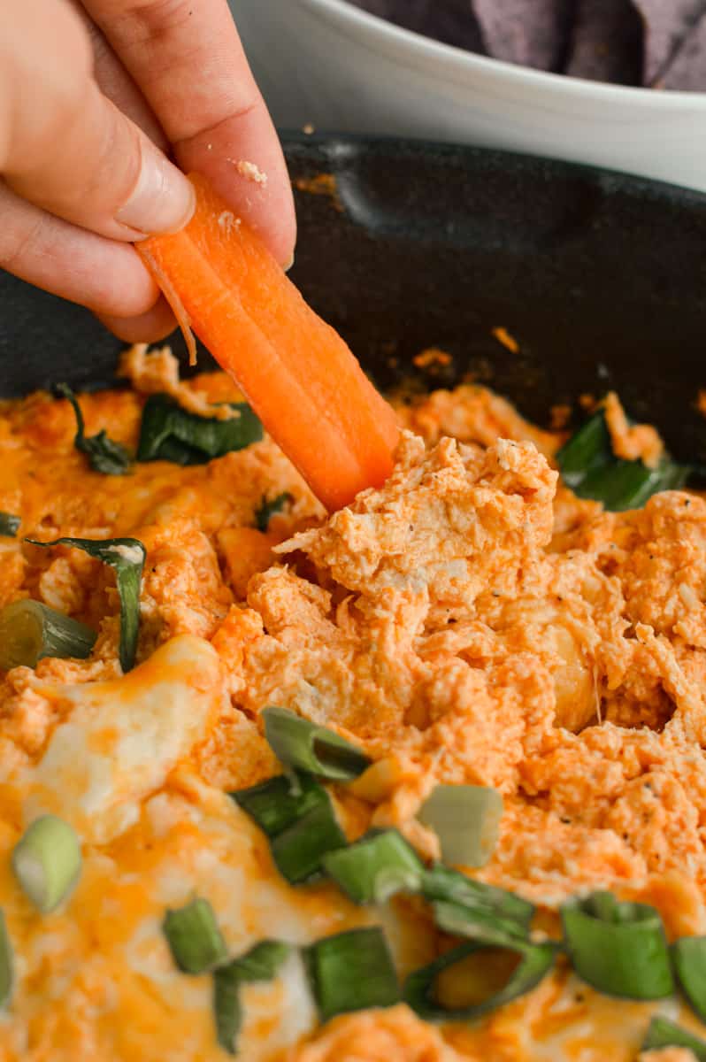 Dipping a carrot stick into buffalo chicken dip.
